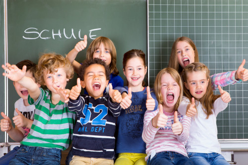 Schulkinder vor einer Tafel